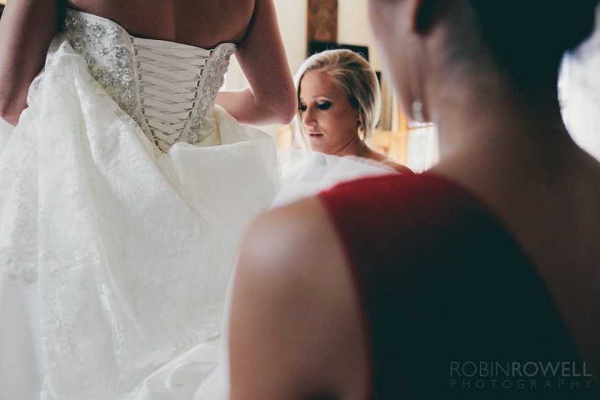 Final adjustments are made to the bride's dress