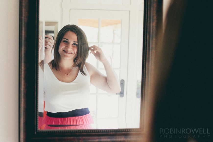 A friend of the bride looks in the mirror as she gets ready