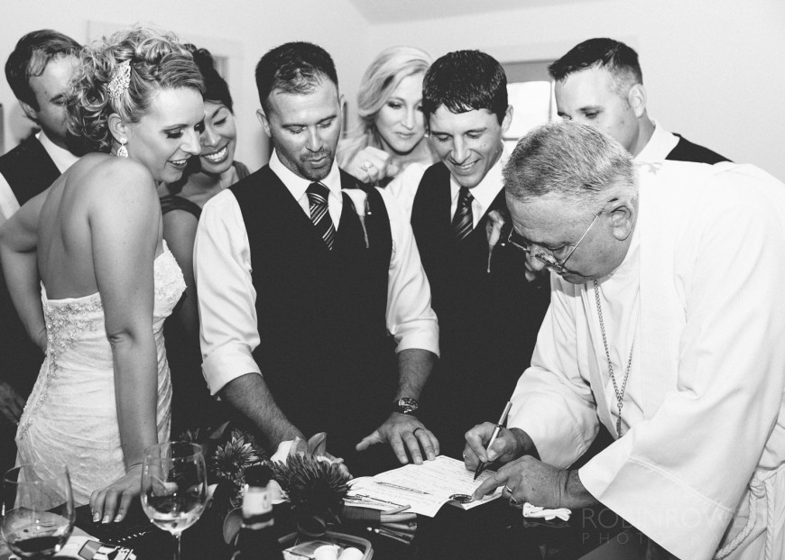 Bridal party observing the signing of the marriage certificate