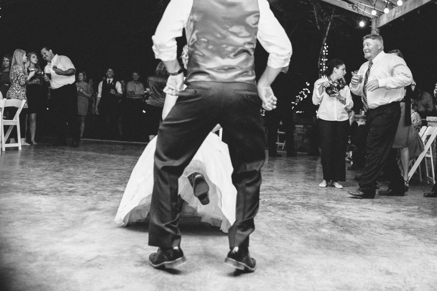 The groom dances in front of the bride before removing her garter