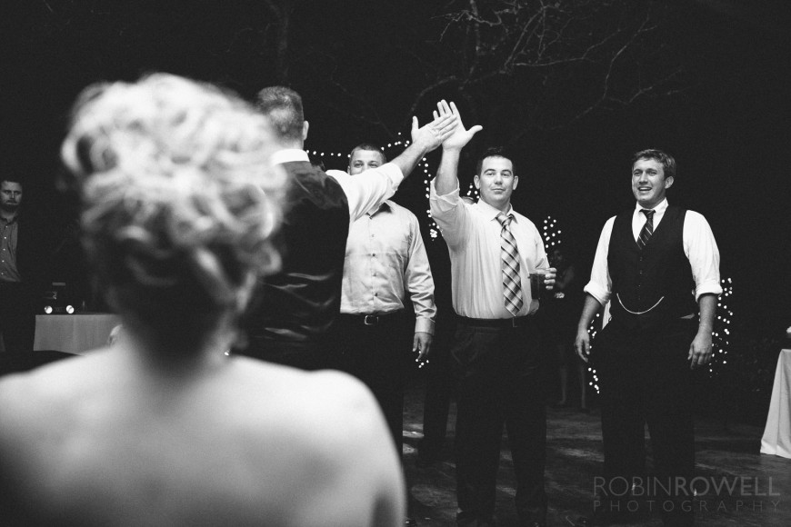 Male guests "high-five" before they prepare to catch the garter