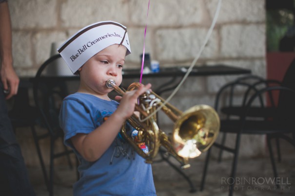 A young boy does his best trying to play a coronet at the Austin Symphony Orchestra "Children's Art Park"