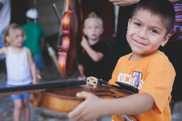 A child gets the opportunity to try playing a violin at the Austin Symphony Orchestra "Children's Art Park"