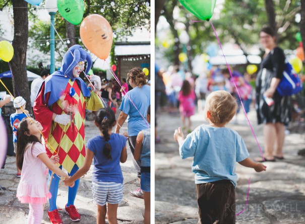 Children, happy with balloons in hand, are welcomed by a jester at the Austin Symphony Orchestra "Children's Art Park"