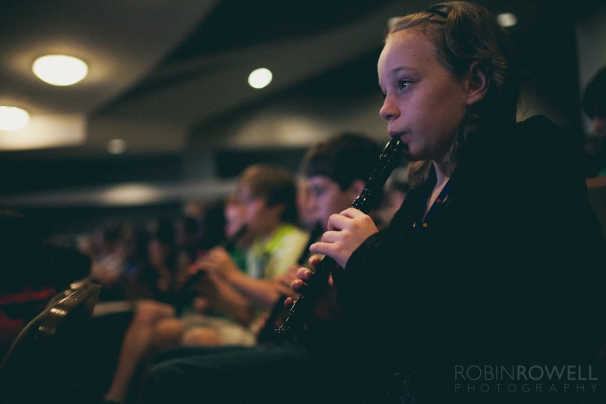 Children play their recorders along with the symphony