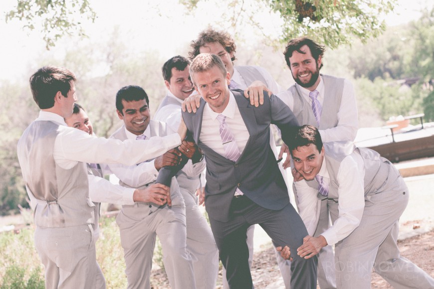 The groomsmen try to hold the groom back - ranch style wedding in Leander, TX