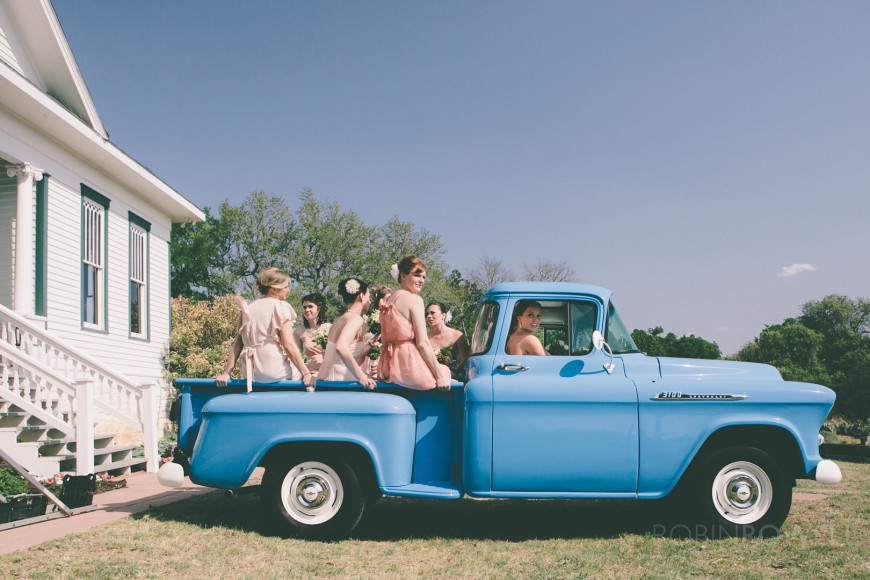 The bride and bridal party wait to be driven to the reception in a classic pickup truck - ranch style wedding in Leander, TX