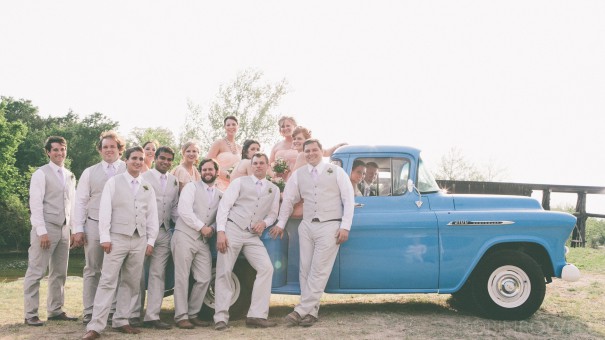 The wedding party pose on and in a classic pickup truck - ranch style wedding in Leander, TX