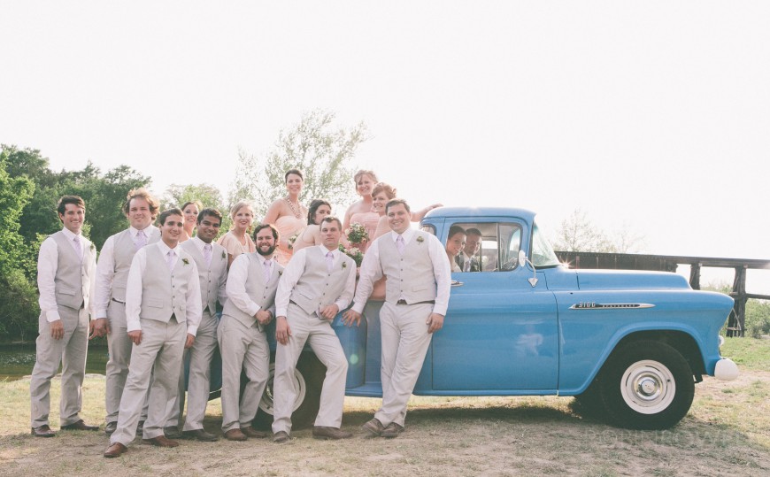 The wedding party pose on and in a classic pickup truck - ranch style wedding in Leander, TX
