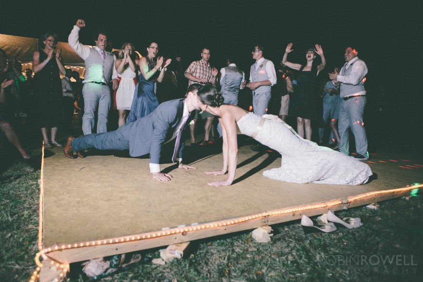 The newlyweds share a crossfit plank kiss to the delight of the guests - ranch style wedding in Leander, TX