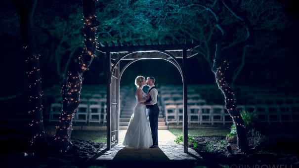 A beautiful backlit photo of the bride and groom under the alter