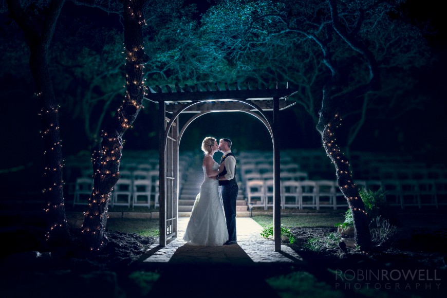 A beautiful backlit photo of the bride and groom under the alter