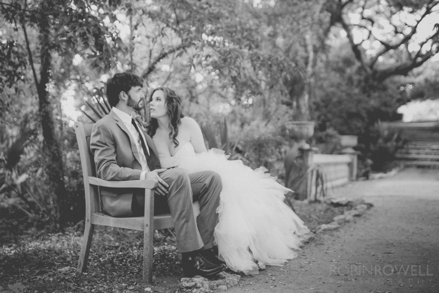 The bride and groom on a bench at Laguna Gloria - Austin, TX