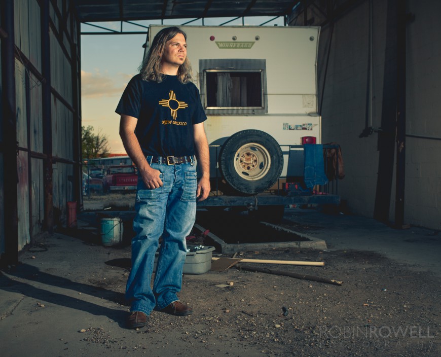 Robin Scott stands before an abandoned trailer