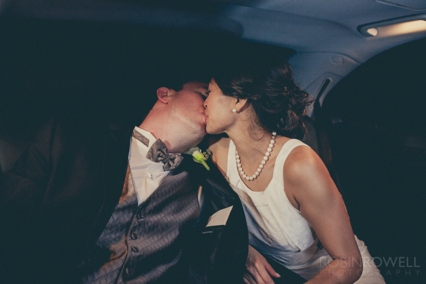 The newlyweds share a kiss in the car as the head out from the wedding reception