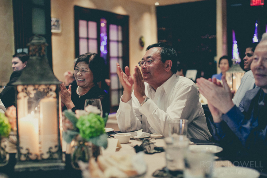 The bride's parent's clap and laugh during the rehearsal dinner at Grotto Ristorante - Woodlands, TX