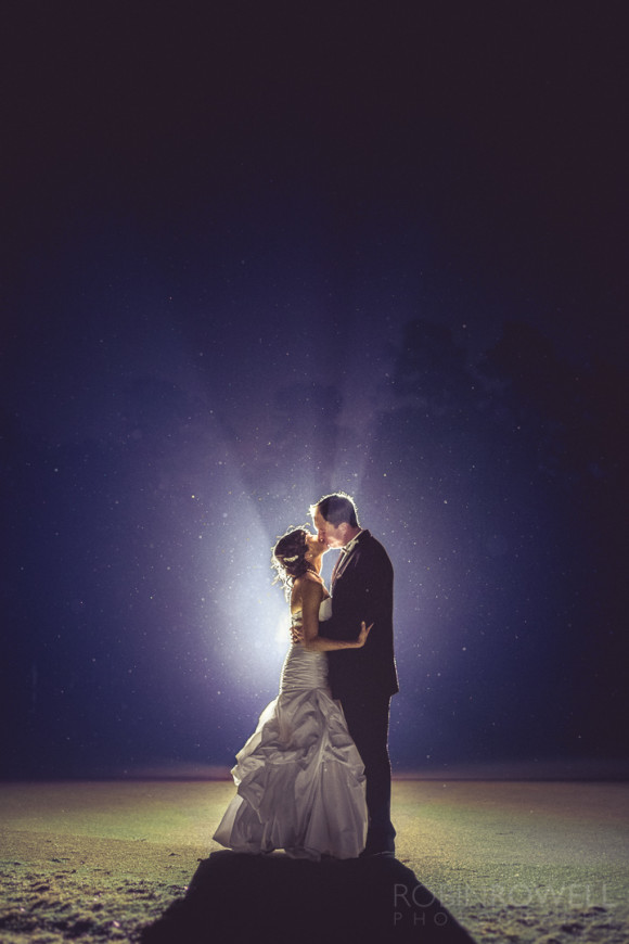 A glamourous photo of the newlyweds engaged in a kiss in the night mist at The Woodlands Country Club - Palmer Course