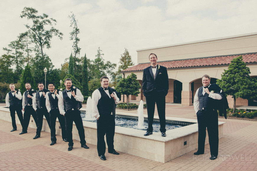 The groomsmen and groom stand by the fountains at The Woodlands United Methodist Church