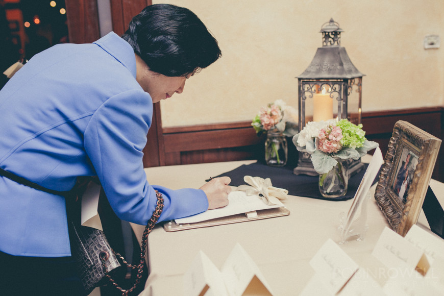 A female guest signs the rehearsal dinner guestbook