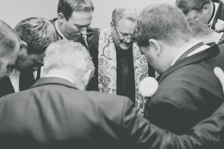 The pastor, groom, and groomsmen gather for prayer before the wedding at The Woodlands United Methodist Church