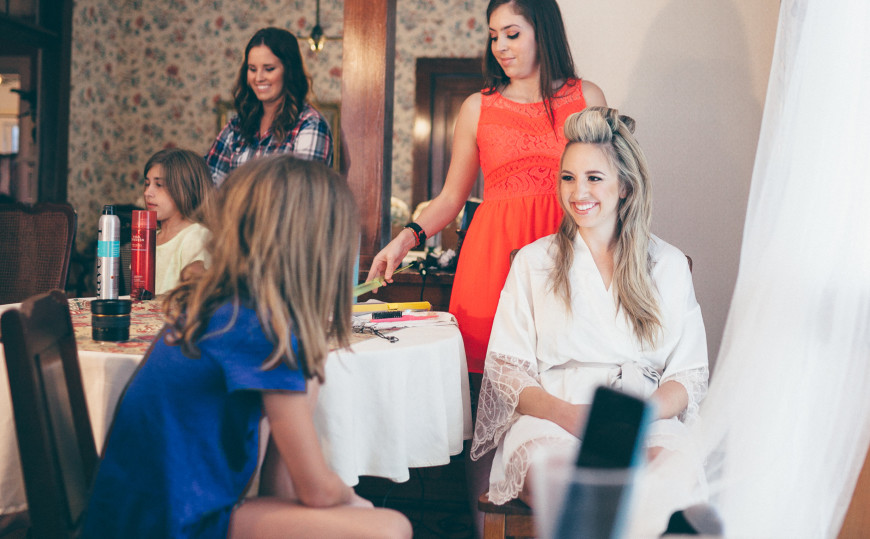 Bride Jamie gets her hair worked on while her younger sister looks on